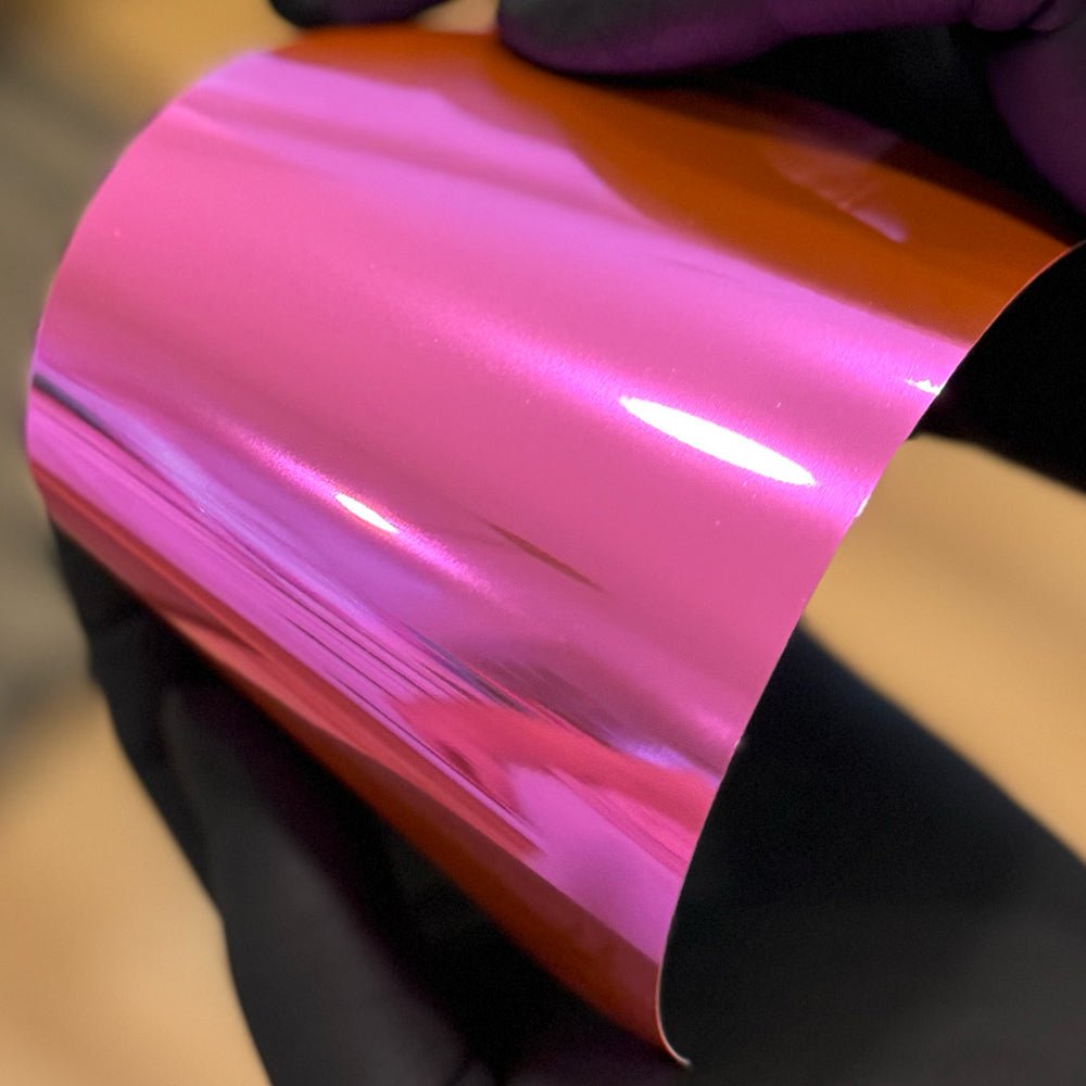 A rolled up piece of pink chrome vinyl material.