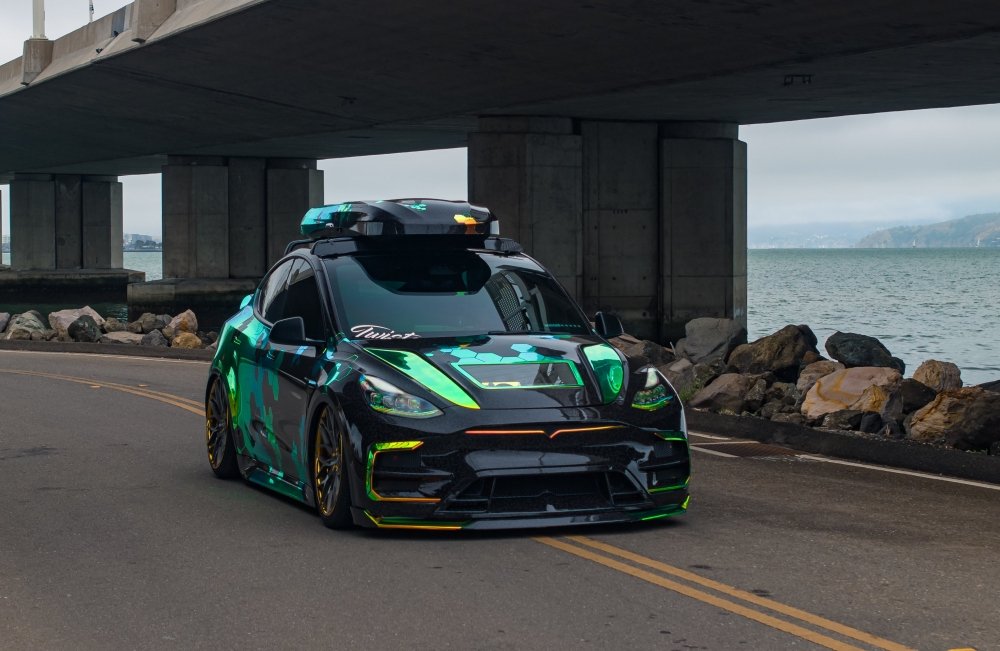 Autonomous car on a road near a body of water with a bridge in the background